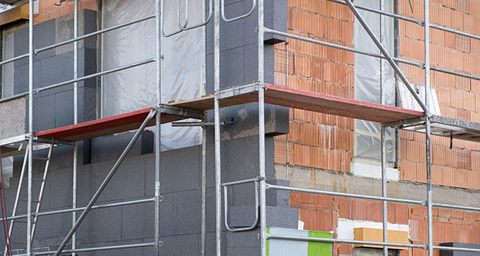 black expanded polystyrene blocks being used as external insulation on a building