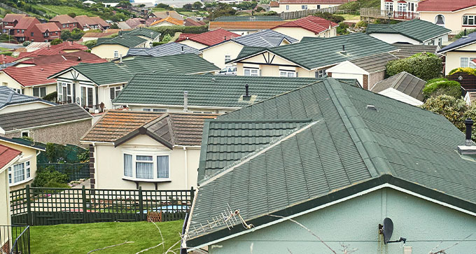 Aerial view of colorful rooftops in a residential area, showcasing a variety of home designs and landscaping.